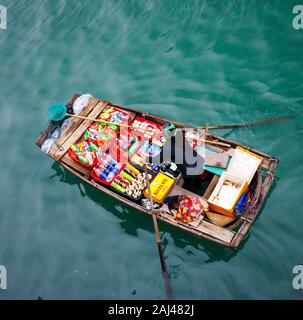 Vendite flottante persone avvicinando le navi da crociera che vendono merci - la Baia di Ha Long, Ha Long, Vietnam Foto Stock