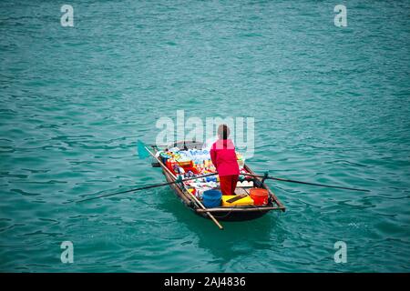 Vendite flottante persone avvicinando le navi da crociera che vendono merci - la Baia di Ha Long, Ha Long, Vietnam Foto Stock