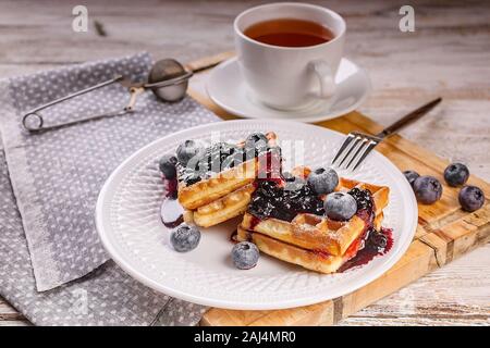 Dolce cialde Viennese con mirtilli e marmellata e una tazza di tè. Il dessert. In casa la cottura. Foto Stock