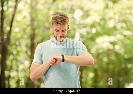 Smart fitness. Montare atleta tracking la sua attività fitness con orologio sportivo. Bello atleta usando tracker fitness durante il corso di formazione esterna. Il monitoraggio Foto Stock