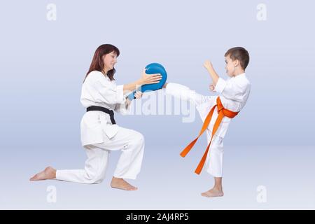 Il figlio e la madre sono la formazione di kick in karategi Foto Stock