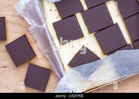 Caramello / biscotti frollini milionari piazze in un stagno e su un tagliere di legno Foto Stock