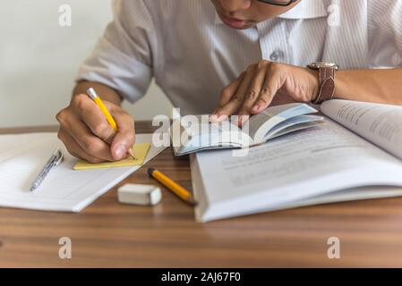 Giovane studente iscritto in una nota adesiva Foto Stock