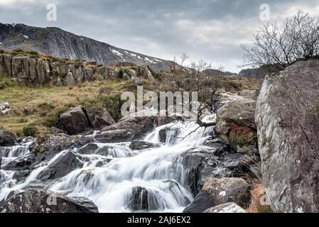 Fast ruscello che scorre a Pont Pen-y-benglog nel Parco Nazionale di Snowdonia nel Galles del Nord Foto Stock