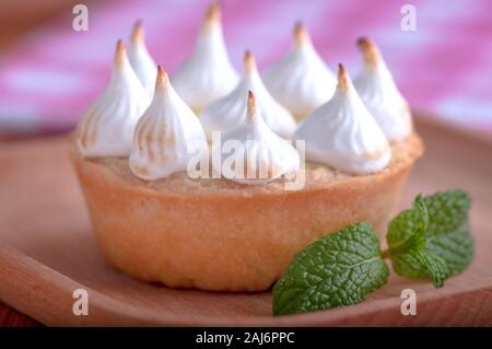 Elegante tortine con limone e curda meringa bruciata dal una fiamma. Molto gustosi tortini. Tartlet riempito con crema di limone (curdo) e meringa Foto Stock