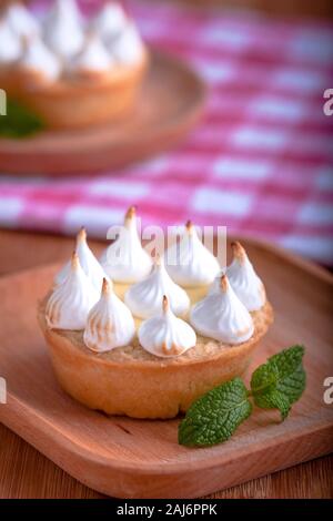 Elegante tortine con limone e curda meringa bruciata dal una fiamma. Molto gustosi tortini. Tartlet riempito con crema di limone (curdo) e meringa Foto Stock