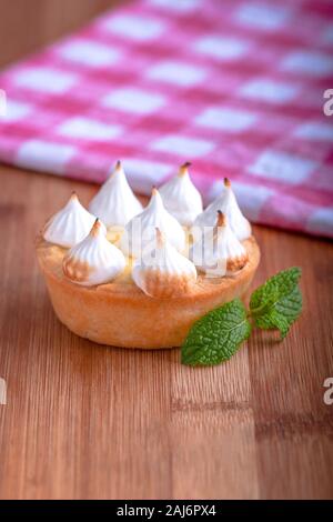 Elegante tortine con limone e curda meringa bruciata dal una fiamma. Molto gustosi tortini. Tartlet riempito con crema di limone (curdo) e meringa Foto Stock