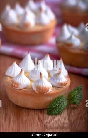 Elegante tortine con limone e curda meringa bruciata dal una fiamma. Molto gustosi tortini. Tartlet riempito con crema di limone (curdo) e meringa Foto Stock