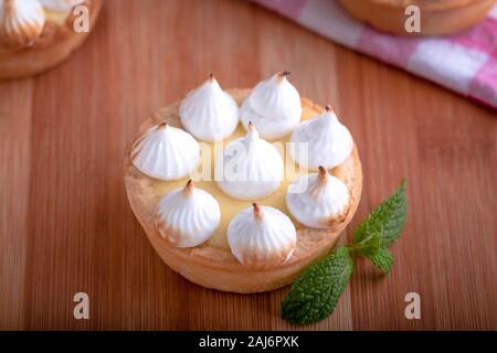 Elegante tortine con limone e curda meringa bruciata dal una fiamma. Molto gustosi tortini. Tartlet riempito con crema di limone (curdo) e meringa Foto Stock