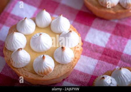 Elegante tortine con limone e curda meringa bruciata dal una fiamma. Molto gustosi tortini. Tartlet riempito con crema di limone (curdo) e meringa Foto Stock