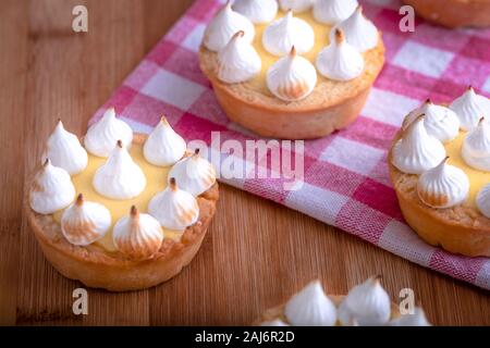 Elegante tortine con limone e curda meringa bruciata dal una fiamma. Molto gustosi tortini. Tartlet riempito con crema di limone (curdo) e meringa Foto Stock