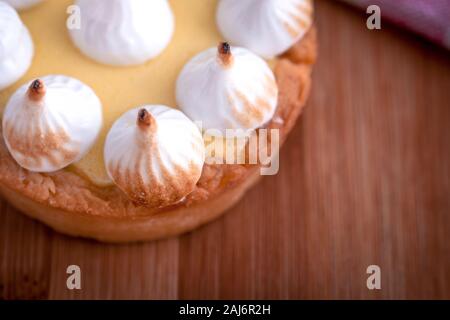 Elegante tortine con limone e curda meringa bruciata dal una fiamma. Molto gustosi tortini. Tartlet riempito con crema di limone (curdo) e meringa Foto Stock