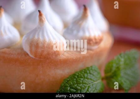 Elegante tortine con limone e curda meringa bruciata dal una fiamma. Molto gustosi tortini. Tartlet riempito con crema di limone (curdo) e meringa Foto Stock