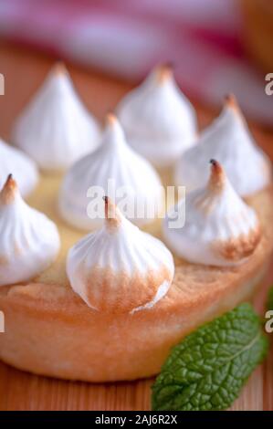 Elegante tortine con limone e curda meringa bruciata dal una fiamma. Molto gustosi tortini. Tartlet riempito con crema di limone (curdo) e meringa Foto Stock