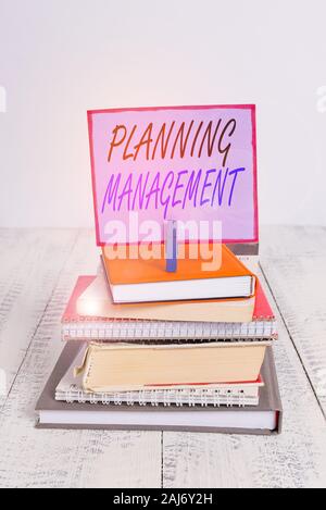 Parola di scrittura di testo gestione della pianificazione. Business photo presentazione di atto o di un processo di fabbricazione o di realizzare i piani pila libri impilati pin notebook vestire Foto Stock