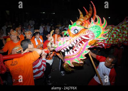 Un drago pupazzo "salutare" un gruppo di uomini in celebrazione del Capodanno cinese festival. Foto Stock