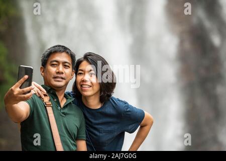 Coppia sta prendendo un selfie sul loro smartphone alla cascata di Ramboda Foto Stock
