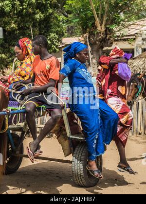 La gente del posto di scendere dal carrello dopo l'arrivo al luogo di destinazione in Senegal, Africa - Fotografia: Tony Taylor Foto Stock