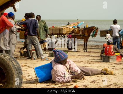 Attesa per la cattura sulla spiaggia sulla costa dal porto di pesca in Joal Fadiout, Senegal Africa - Fotografia: Iris de Reus Foto Stock