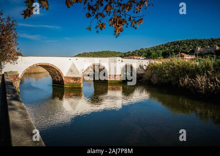 La luce del sole e i riflessi dell'antico ponte romano sul fiume Arado in Silves, Algarve Portogallo. Fotografia: Tony Taylor Foto Stock