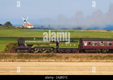 LNER B12 - 8572 locomotiva a vapore passando Weybourne mulino a vento del nord Stazione di Norfolk Foto Stock