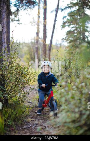 Il ragazzo guarda felice mentre guida la sua moto Foto Stock