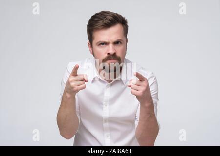 Iracondo con la barba accusando voi, puntare il dito a voi. Si sono resi colpevoli. Studio shot Foto Stock