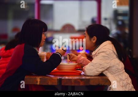 (200103) -- LIUZHOU, gen. 3, 2020 (Xinhua) -- la gente mangia lumaca sul fiume riso tagliatelle in un ristorante a Liuzhou, sud della Cina di Guangxi Zhuang Regione autonoma, Gen 2, 2020. La combinazione di cibi tradizionali materiali di Han persone con Miao e Dong gruppi etnici, fiume lumaca spaghetti di riso, o 'Luosifen' in cinese, è un piatto di spaghetti di riso bollito con decapati germogli di bambù, essiccato rapa, verdure fresche e noccioline nel fiume speziate zuppa di lumaca. La specialità, la cui creazione è stato elencato come parte del Guangxi il patrimonio culturale immateriale in 2008, è diventato uno dei più ricercati piatti dopo aver Foto Stock