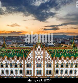 Budapest, Ungheria - vista aerea del Tesoro di Stato edificio con il famoso tetto colorato. Bastione del Pescatore e golden sunset in background. Tetto Foto Stock