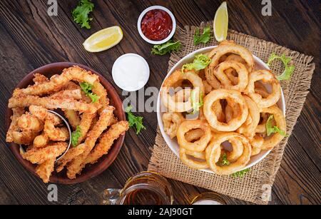 Donna che immerge croccante anello di cipolla fritta in salsa, primo piano  Foto stock - Alamy