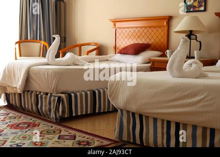 Camera da letto interior design con cigni dalla decorazione asciugamano sul lettino Foto Stock