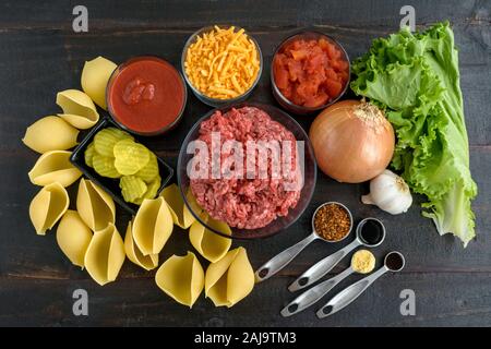 Cheeseburger gusci ripieni Ingredienti: Materie di macinato di manzo, jumbo gusci di pasta e altri ingredienti per fare una pasta al forno piatto Foto Stock