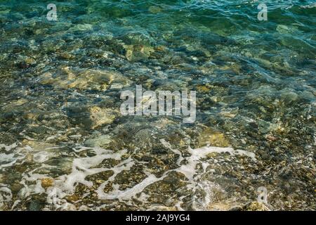 Schizzi dalle onde andando a sbattere contro la costa rocciosa Foto Stock