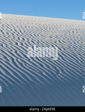 Fluttuazioni nella sabbia bianca contro il cielo chiaro al White Sands National Park in New Mexico Foto Stock