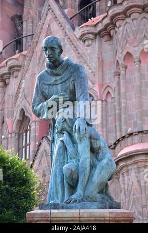 Statua di Fray Juan de San Miguel in fronte a La Parroquia de San Miguel Arcangel; San Miguel De Allende, Messico Foto Stock