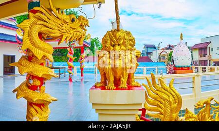 La statua di golden quattro corpi di leone alla colonna di drago in Sam Sae Chu rifugio santuario cinese, città di Phuket, Tailandia Foto Stock