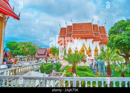 CHALONG, Tailandia - 30 Aprile 2019: la bella santuari di Wat Chalong tempio sono circondato da verde e lussureggiante giardino con aiuole di fiori e piante topiaria da Foto Stock