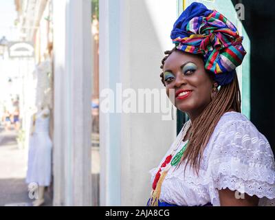 Felice donna brasiliana della discesa africana vestite nei tradizionali costumi Baiana nel centro storico di Salvador de Bahia, in Brasile. Foto Stock