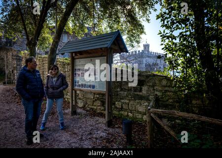 GUBBIO, Italia - 01 gennaio 2020: due turisti sconosciuto controllare i segni nel parco Ranghiasci in inverno, sullo sfondo il palazzo ducale di Gubbio, Foto Stock