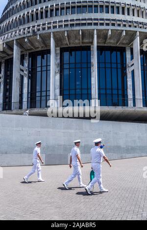 Un gruppo di tre ufficiali militari che camminano di fronte all'edificio governativo 'The Beehive' di Basil Spence e Fergus Sheppard, Wellington, Nuova Zelanda Foto Stock