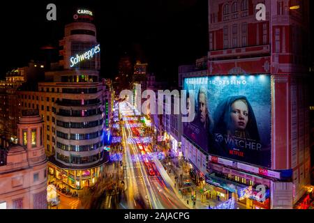 Il famoso luci dell'edificio Schweppes e Gran Via visto da dietro una finestra con alcune riflessioni. La Gran Via è come Broadway a New York piena di th Foto Stock