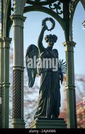 Dettagliata statua di pietra di un angelo su un cimitero tedesco a Berlino su un soleggiato luminosa giornata invernale Foto Stock