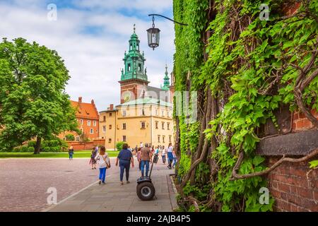 Cracovia in Polonia - Giugno 18, 2019: Il Castello Reale di Wawel vista colorate, parete verde e segway, persone a Cracovia Foto Stock