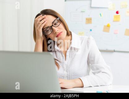 Donna stanca al lavoro al computer. Mal Di Testa. Foto Stock