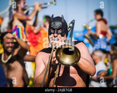 Musicista mascherato giocando il trombone durante il carnaval street parade di Rio de Janeiro in Brasile. Foto Stock