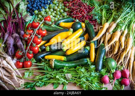 Ortaggi freschi su una tavola come le zucchine, le radici di prezzemolo, pomodori Foto Stock