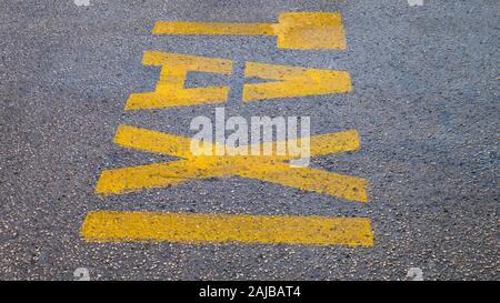 La parola GIALLO TAXI sul marciapiede. Taxi contrassegnato sul pavimento di una strada. Taxi posto cartello stradale stazione simbolo giallo lettere sulla strada della citta'. Foto Stock