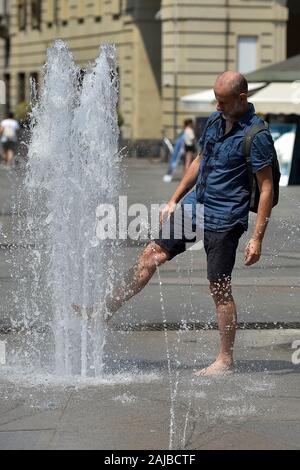 Torino, Italia - 24 July, 2019: un uomo aggiorna se stesso con l'acqua di una fontana pubblica. Un eccessivo riscaldamento spia è stato designato in 13 città italiane. Credito: Nicolò Campo/Alamy Live News Foto Stock
