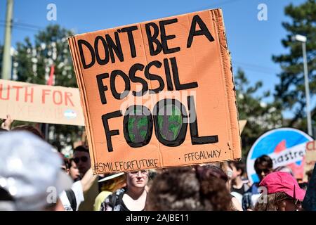 Lausanne, Svizzera - 09 August, 2019: una lettura del segno "non essere un fossile fool' è sostenuto da un attivista del clima durante un venerdì di sciopero in futuro per la protezione del clima che è parte del 'SMILE per futuri' dell'evento. Più di 450 giovani attivisti del clima provenienti da diversi paesi europei si sono riuniti per partecipare al vertice "miglio per il futuro", che sta per un incontro estivo in Europa di Losanna. Obiettivo del vertice è quello di rafforzare i legami tra i partecipanti della gioventù europea clima movimento di sciopero e di definire il futuro della mobilitazione contro il cambiamento climatico. Credito: Nicolò Campo/Alamy Foto Stock