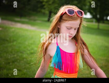 Giovane ragazza con capelli rossi in costume da bagno e occhiali da sole Foto Stock